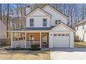 Charming two-story home with a well-manicured lawn, attached garage, and inviting covered porch at 851 Ashley Ln, Stone Mountain, GA 30087