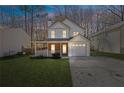 Charming two-story home with a front porch, attached garage, and well-manicured lawn at 851 Ashley Ln, Stone Mountain, GA 30087