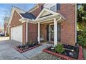 Close-up view of a home's brick front entrance with a decorated door and landscaped garden beds at 1039 Bramble Way, Grayson, GA 30017