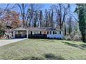 Charming one-story home with a manicured lawn, red front door, and attached carport at 2945 Monterey Dr, Decatur, GA 30032
