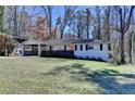 Charming one-story home with a manicured lawn, red front door, and attached carport at 2945 Monterey Dr, Decatur, GA 30032