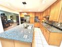 This kitchen features tile floors, wood cabinets, stainless steel appliances, and an island with a granite countertop at 4341 Kings Ne Way, Marietta, GA 30067