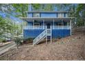 Charming two-story home featuring a large porch, blue siding, and mature trees at 1083 Lake Dr, Snellville, GA 30039