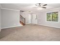Open living room with neutral carpet, staircase and bright natural light at 1083 Lake Dr, Snellville, GA 30039