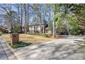 A brick house sits on a well-maintained lawn with a long driveway leading to a side-entry garage at 160 Wing Mill Rd, Sandy Springs, GA 30350