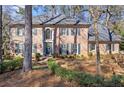 A beautiful, two-story brick home with manicured landscaping creates a welcoming curb appeal at 160 Wing Mill Rd, Sandy Springs, GA 30350