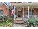 Inviting front porch with brick accents and classic white columns and railings at 1811 Mcconnell Rd, Grayson, GA 30017