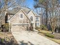 Charming home featuring a two-car garage, manicured lawn, and a welcoming front entrance and beige stucco at 217 Colonial Dr, Woodstock, GA 30189