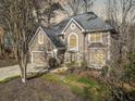 Lovely landscaped home featuring a two-car garage, manicured lawn, and an inviting front entrance in a wooded lot at 217 Colonial Dr, Woodstock, GA 30189
