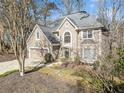 Beautifully landscaped home featuring a two-car garage, manicured lawn, and an inviting front entrance in a wooded lot at 217 Colonial Dr, Woodstock, GA 30189