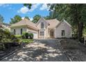 Elegant exterior with stone accents, arched entryway, and a driveway leading to a two-car garage at 370 Royal Birkdale Ct, Duluth, GA 30097