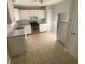 Well-lit kitchen featuring white cabinets, stainless steel appliances, and tile floors at 6104 Cobblestone Ct, Douglasville, GA 30134