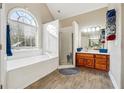 Bright bathroom featuring a large arched window, soaking tub, and separate glass shower at 429 Telluride Ct, Locust Grove, GA 30248
