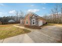 Spacious driveway and side view of a home with stone accents and a well-maintained yard at 429 Telluride Ct, Locust Grove, GA 30248