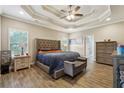 Bedroom showcasing a stylish tray ceiling, plank flooring, and elegant furnishings at 429 Telluride Ct, Locust Grove, GA 30248
