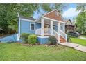 Inviting exterior view of a blue home featuring a classic front porch and well-manicured lawn at 125 Warren Ne St, Atlanta, GA 30317