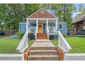 Quaint blue home with a welcoming front porch and well-manicured lawn, capturing a sense of charm at 125 Warren Ne St, Atlanta, GA 30317
