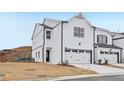 View of a new construction townhome featuring a two-car garage and modern farmhouse architecture at 6363 Apalachee Se Way, Smyrna, GA 30126