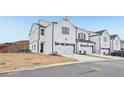 View of a row of new construction townhomes featuring a two-car garage and modern farmhouse architecture at 6363 Apalachee Se Way, Smyrna, GA 30126