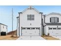 View of a new construction townhome featuring a two-car garage and modern farmhouse architecture at 6363 Apalachee Se Way, Smyrna, GA 30126