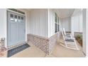 Close up of the inviting covered front porch with rocking chairs, door, and a welcoming rug at 124 Redford Ln, Canton, GA 30115