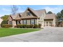 Traditional home showcasing a manicured lawn, attached garage, and a blend of stone and siding at 1656 Maes Overlook, Loganville, GA 30052
