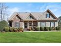 Attractive single-Gathering home with stone and siding, complemented by a green lawn and manicured bushes at 1656 Maes Overlook, Loganville, GA 30052