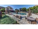 Community pool featuring lounge chairs, tables with umbrellas, and surrounding manicured landscaping at 4206 Whitby Se Way # 15, Smyrna, GA 30080