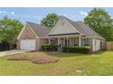 Charming single Gathering home with brick accents, manicured lawn, and a two-car garage at 239 Gilliam Ct, Locust Grove, GA 30248