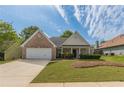 Charming single Gathering home with brick accents, manicured lawn, and a two-car garage at 239 Gilliam Ct, Locust Grove, GA 30248