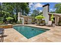 Backyard swimming pool and lounge area with stone patio, umbrellas and plenty of seating at 750 Crest Valley Nw Dr, Sandy Springs, GA 30327