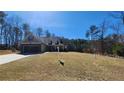 View of the home from the side, with a sprawling front lawn and mature trees surrounding the property at 275 Bridgemill Dr, Douglasville, GA 30134
