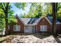 Quaint brick home with a gabled roof, surrounded by lush greenery and mature trees at 17 Peachtree Ne Ave, Atlanta, GA 30305