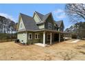Charming two-story home with a covered porch, green siding, and a large propane tank out back at 529 Claude Scott Rd, Canton, GA 30115