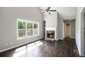 Inviting living room with a cozy fireplace, built-in shelves, large windows, hardwood floors, and a vaulted ceiling at 221 Makayla Way, Temple, GA 30179