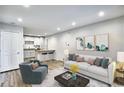 Comfortable living room adjacent to a kitchen with stainless steel appliances and barstool seating at 2657 Lenox Ne Rd # 29-1, Atlanta, GA 30324