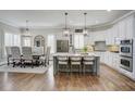 Spacious kitchen with white cabinets, gray island, stainless steel appliances, and hardwood floors at 6640 Eastleigh Cir, Suwanee, GA 30024