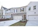 Townhome exteriors featuring brick accents, multiple windows, attached garages, and manicured landscaping at 213 Admor Ln, Acworth, GA 30102