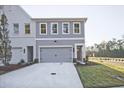 New construction townhome showcasing gray and white color schemes, a private driveway, and a well-kept lawn at 221 Admor Ln, Acworth, GA 30102