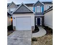 Home exterior with a two-car garage, gray shingles, and a stone-accented front entrance at 1510 Paramount Ln, Sugar Hill, GA 30518