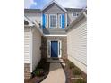Home featuring a stone wall with a blue door, blue shutters, and lovely landscaping at 1510 Paramount Ln, Sugar Hill, GA 30518