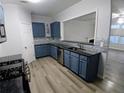 Modern kitchen with stainless steel appliances, blue cabinets, and gray countertops at 1510 Paramount Ln, Sugar Hill, GA 30518