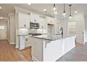 Modern kitchen featuring a granite island, stainless steel microwave, white cabinetry, and stylish pendant lighting at 205 Admor Ln, Acworth, GA 30102