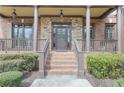 Charming front porch with stone accents, wooden pillars, and manicured shrubs leading to the front door at 3060 Salisbury Ln, Cumming, GA 30041