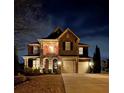 Night view of a beautiful brick home with a two-car garage and illuminated porch at 6125 Allison Rd, Cumming, GA 30040