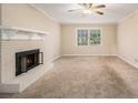 Cozy living room featuring a classic brick fireplace and neutral carpeting at 1731 Fieldgreen Overlook, Stone Mountain, GA 30088