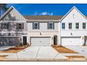 Townhomes with vertical siding, brick accents, a two-car garage, and professional landscaping at 405 Carrera Ln, Acworth, GA 30102