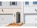 Townhome with brick accents, an arched entry, a two-car garage, and professional landscaping at 405 Carrera Ln, Acworth, GA 30102