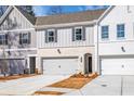 Townhome with a two-car garage, featuring vertical siding with brick accents at 405 Carrera Ln, Acworth, GA 30102