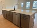 Modern kitchen island featuring light countertops, dark cabinets, and stainless steel appliances at 405 Carrera Ln, Acworth, GA 30102